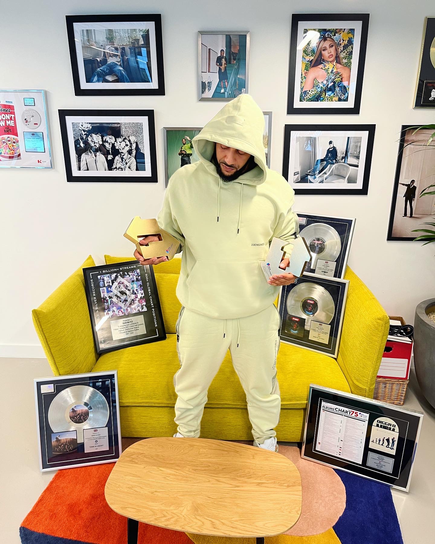 Sean Murdz holding awards beside his music certifications