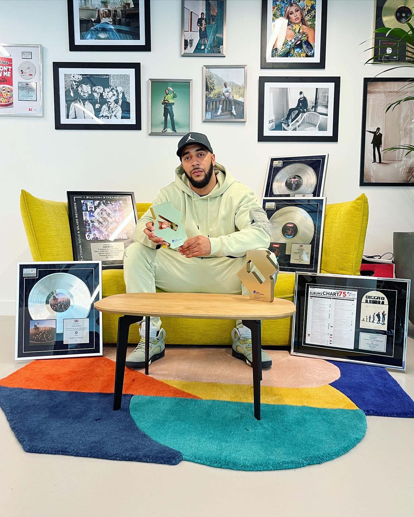 Sean Murdz seated with his awards and music certifications